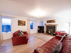 a living room with two couches and a fireplace at Dalvista Cottage in Leurbost