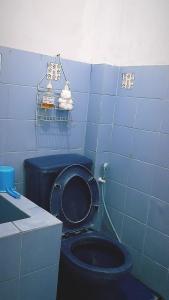 uma casa de banho azul com um WC preto e um lavatório em Singgah Macanan em Sentool