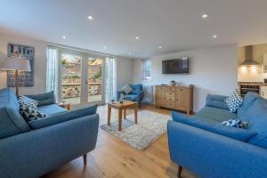 a living room with blue couches and a tv at Stone Lodge in Hunstanton