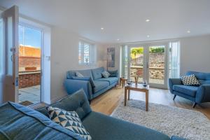 a living room with blue couches and a table at Stone Lodge in Hunstanton