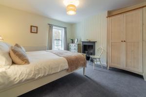 une chambre avec un lit, un bureau et une chaise dans l'établissement Petts Cottage, à Burnham Market
