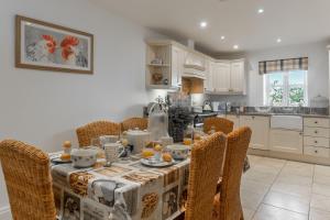 a dining room with a table with chairs and a kitchen at The Moorings in Wells next the Sea