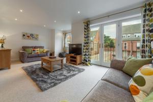 a living room with a couch and a tv at The Moorings in Wells next the Sea