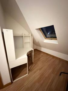 Kleines Zimmer mit einem Schreibtisch und einem Dachfenster. in der Unterkunft Relaxing Room in Spacious House in London