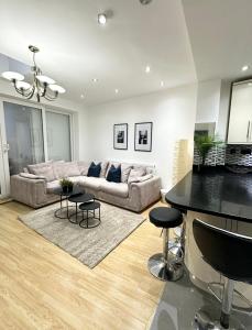 ein Wohnzimmer mit einem Sofa und einem Tisch in der Unterkunft Relaxing Room in Spacious House in London