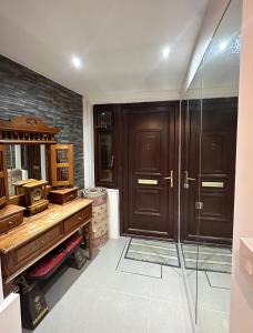 ein Bad mit einem Holzschreibtisch und einer Glasdusche in der Unterkunft Relaxing Room in Spacious House in London