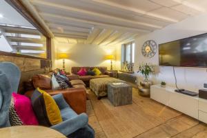 a living room with a couch and a flat screen tv at Hideaway Barn 4 in Thornham