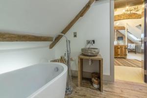 a bathroom with a bath tub and a sink at Hideaway Barn 4 in Thornham +16 photos