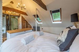 a large white bed in a room with windows at Hideaway Barn 4 in Thornham