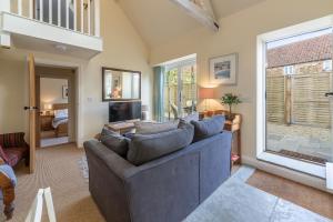 a living room with a couch and a large window at The Little Barn in Ringstead