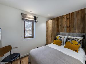 sypialnia z dużym łóżkiem z drewnianym zagłówkiem w obiekcie Appartement Courchevel - 3 chambres, 6 personnes, cheminée, parking, Wi-Fi - FR-1-564-91 w Courchevel