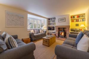 a living room with two couches and a fireplace at Sea Holly House in Blakeney