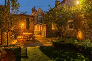 a garden at night with a table and chairs at Sea Holly House in Blakeney