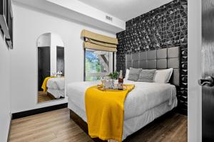 a bedroom with a bed with a yellow blanket on it at The Mountaineer by InstantSuites Pool & HotTub in Canmore