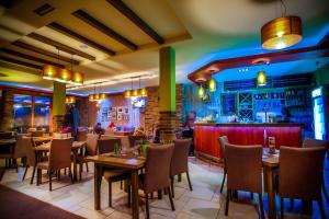 a restaurant with tables and chairs and a bar at Hotel Moja Čarda in Temerin