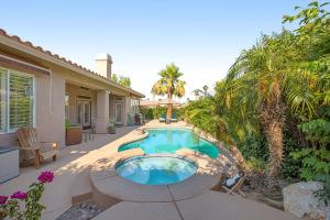 un patio trasero con piscina y palmeras en Whitehawk At Palm Desert, en Palm Desert