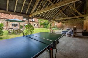 a ping pong table in the middle of a patio at The Tack House in Holkham