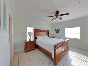 a bedroom with a bed and a ceiling fan at Villas on the Gulf #N1 in Pensacola Beach +23 photos