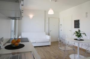 Il comprend une cuisine et un salon avec une table et un canapé. dans l'établissement Housing32 Apartments, à Milan