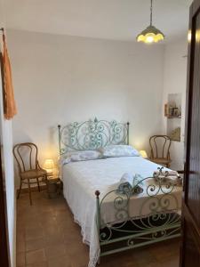 a bedroom with a bed and two chairs in it at Appartamento Vista Mare - Amazing Sea View Apartment in Stintino