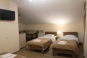 2 camas individuales en una habitación con cocina en Nitsa Guest House, en Gori
