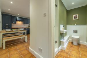 a kitchen with a sink and a toilet in a room at Diggers Rest in Burnham Market +16 photos