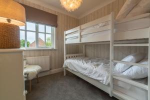 a bedroom with bunk beds and a chandelier at Diggers Rest in Burnham Market