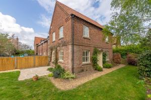 a brick house with a yard in front of it at Diggers Rest in Burnham Market