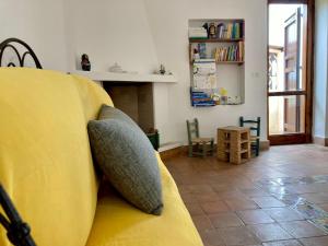 a yellow couch in a living room with a window at Appartamento Vista Mare - Amazing Sea View Apartment in Stintino