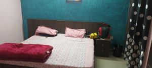 1 dormitorio con cama con almohadas rosas y mochila en OYO Hotel RK, en Manesar