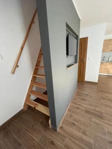 een woonkamer met een trap en een televisie bij Całoroczny domek - bliźniak 