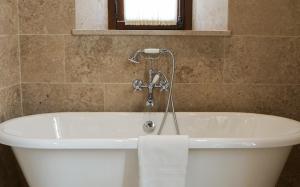 a bath tub with a faucet in a bathroom at Château Sainte Sabine in Sainte-Sabine