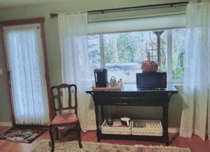 Zimmer mit einem Klavier, einem Stuhl und einem Fenster in der Unterkunft Sunrise Suite on the Sound in Anacortes