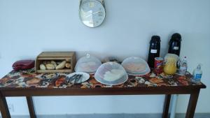 a table with a clock and a box of food at pousada costa do meio in Saquarema