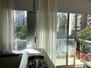 Habitación con ventana grande con cortinas blancas. en Hermoso Studio en Recoleta con Piscina y Laundry en Buenos Aires