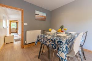 a dining room with a blue and white table and chairs at Basil Cottage in Wells next the Sea