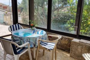 una mesa y sillas en una habitación con ventanas en maison rez de jardin 2 à 4 personnes, en Le Lavandou