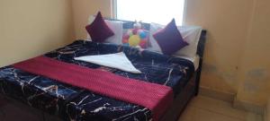 Een bed of bedden in een kamer bij POP Sarthak Hotel