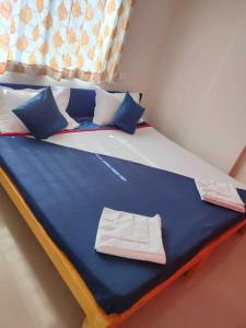 een groot bed met blauwe lakens en blauwe kussens bij Hotel Chalukya Executive in Pune