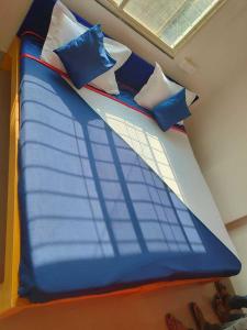 een bed met blauwe en witte kussens erop bij Hotel Chalukya Executive in Pune