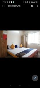 een slaapkamer met een groot bed met kussens erop bij Hotel Chalukya Executive in Pune