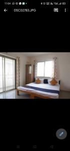 een slaapkamer met een groot bed en 2 ramen bij Hotel Chalukya Executive in Pune