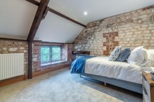 um quarto com uma parede de tijolos em Old Smithy em Titchwell