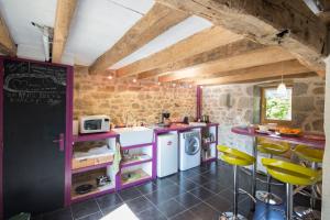 uma cozinha com armários roxos e bancos amarelos em Maison d'Hotes ZEN 