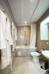 a bathroom with a tub and a toilet and a sink at Hotel Palladium in Odesa