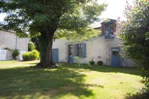 a house with a tree in the yard at Maison d'Hotes ZEN 