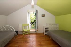 um quarto com 2 camas, uma secretária e uma janela em Maison d'Hotes ZEN 