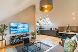 ein Wohnzimmer mit einem Sofa und einem TV an der Wand in der Unterkunft Oakfield Premier Apartments - Fast Wifi - 5 mins City Centre in Cardiff