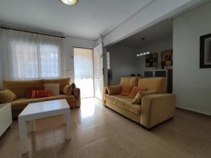 Sala de estar con 2 sofás y mesa en El Bungalow de Javi, en Gran Alacant