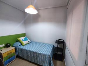 Dormitorio pequeño con cama y lámpara en El Bungalow de Javi, en Gran Alacant